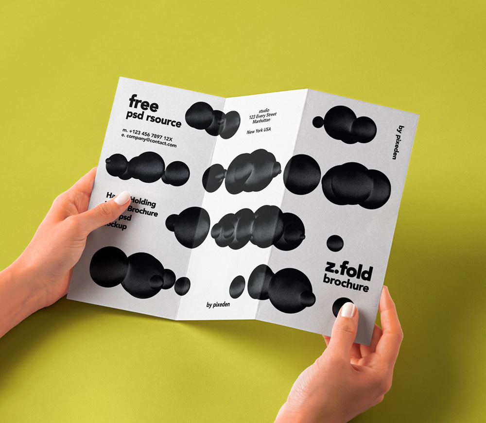 Free Holding Folded Brochure Mockup